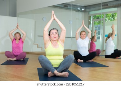 Group Of Mature Active Women Practicing Yoga, Standing Together In Asana