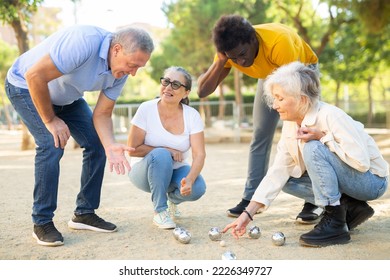 Group Of Mature Adult Men And Women Of Different Age Playing Petanque Game In The City Park On A Sunny Day