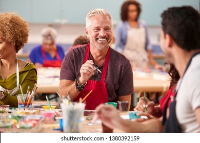 Group Of Mature Adults Attending Art Class In Community Centre