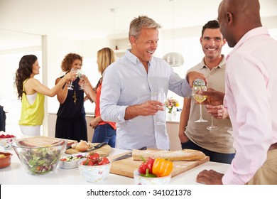 Group Of Mature Friends Enjoying Dinner Party At Home