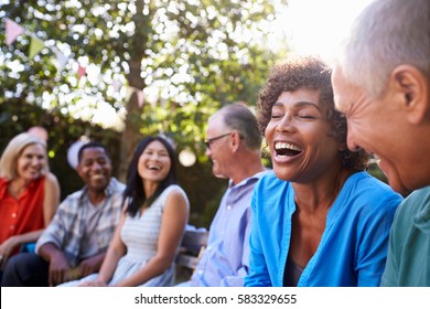 Group Of Mature Friends Socializing In Backyard Together