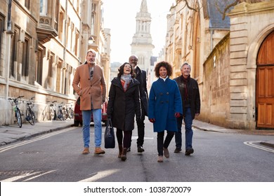 Group Of Mature Friends Walking Through City In Fall Together