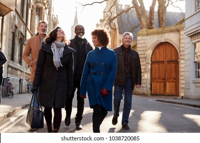 Group Of Mature Friends Walking Through City In Fall Together