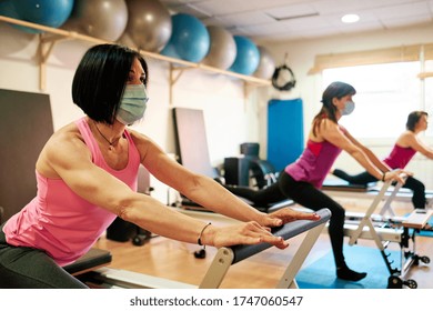 Group Of Mature Women Doing Excercise, Pilates And Yoga With Social Distancing And Face Mask