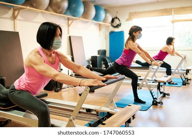 Group Of Mature Women Doing Excercise, Pilates And Yoga With Social Distancing And Face Mask