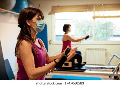 Group Of Mature Women Doing Excercise, Pilates And Yoga With Social Distancing And Face Mask