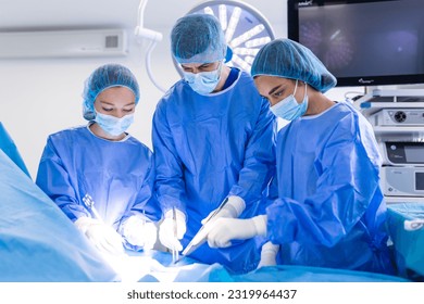 Group of medical team urgently doing surgical operation and helping patient in theater at hospital. Medical team performing surgical operation in a bright modern operating room - Powered by Shutterstock