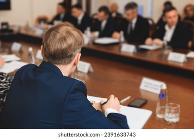 Group of men in business suits talking and discussing at conference, politicians and entrepreneurs debate, networking and negotiate, businessmen have dialog conversation on a forum, panel discussion