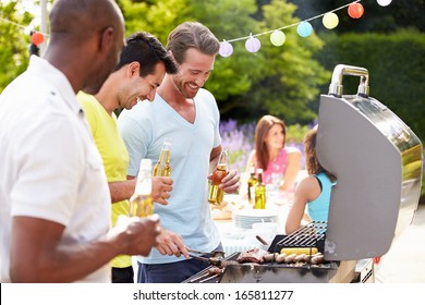 Group Of Men Cooking On Barbeque At Home