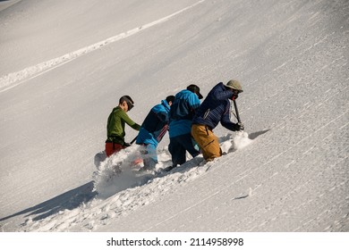 Group Of Men Are Digging Snow And Checking The Mountain For Avalanche Safety. Making Schurf. Freeride Concept