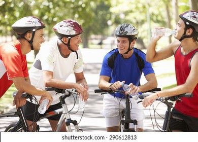 Group Of Men Resting During Cycle Ride Through Park