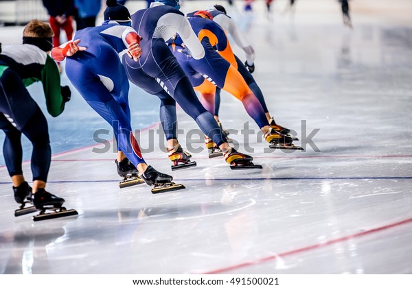 group of men skating on ice sports arena.\
warm-up before competitions in speed\
skating