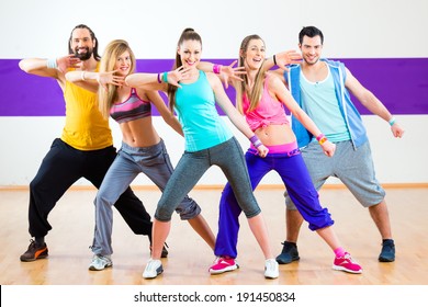 Group of men and women dancing zumba fitness choreography in dance school