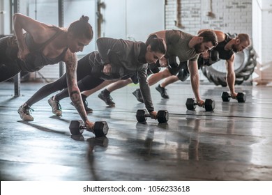 Group of men and women doing workouts together at gym.