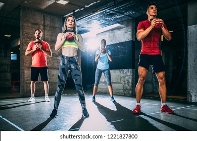 Group of men and women exercising with kettlebell. - Shutterstock ID 1221827800