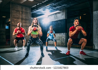 Group of men and women exercising with kettlebell. - Shutterstock ID 1221827803