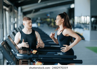 A group of men and women, led by a male instructor, participating in a vigorous workout session at the gym to enhance their overall fitness levels. - Powered by Shutterstock