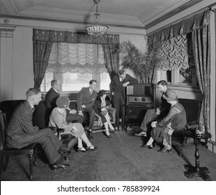 Group Of Men And Women Listening To A Radio In The Hamilton Hotel, Washington, D.C. The Atwater Kent Radio Features An Enclosed Speaker At The Top Of The Cabinet. The Photo Was Associated With Thomas