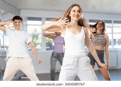 Group of men and women in sportswear dancing hip hop in dance studio - Powered by Shutterstock