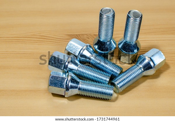 A group of\
metal bolts securing a car\
wheel.