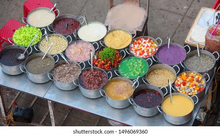 Group of metal pots on a vietnamese street stall containing various kinds of  colorful sweet soups Che hem Hue Vietnam