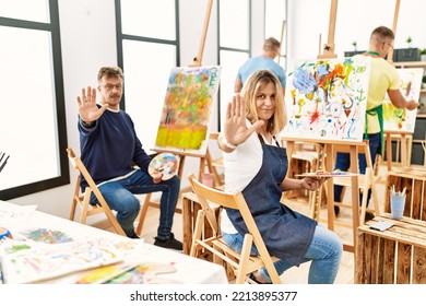 Group Of Middle Age Artist At Art Studio Doing Stop Sing With Palm Of The Hand. Warning Expression With Negative And Serious Gesture On The Face. 