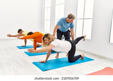 Group Of Middle Age People Training With Personal Trainer At Sport Center.