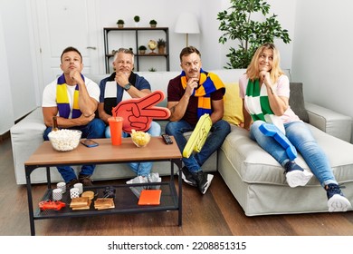 Group Of Middle Age People Wearing Team Scarf Cheering Football Game Serious Face Thinking About Question With Hand On Chin, Thoughtful About Confusing Idea 