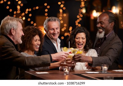 Group Of Middle Aged Friends Celebrating In Bar Together