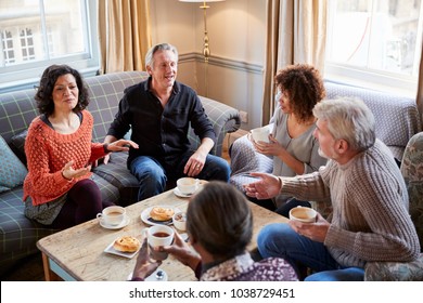 Group Of Middle Aged Friends Meeting Around Table In Coffee Shop