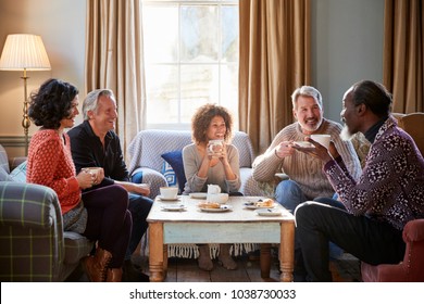 Group Of Middle Aged Friends Meeting Around Table In Coffee Shop