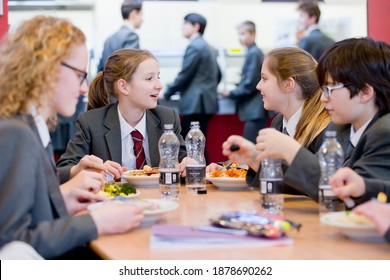 A Group Of Middle School Students Eating Lunch In The School Cafeteria.