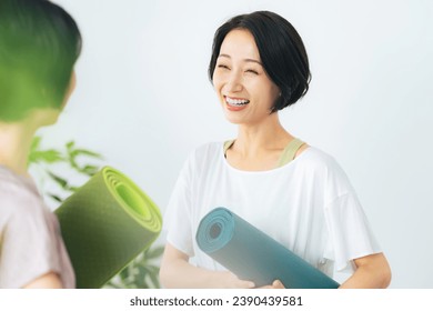 A group of middle-aged women talking in sports gym. Yoga studio. - Powered by Shutterstock