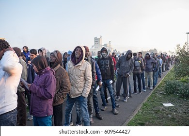 A group of migrants and refugees wait to leave the Jungle camp, Calais, France. November 2016. - Shutterstock ID 609544427