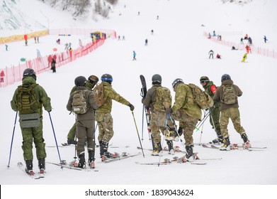 group of military special force unit men in camouflage green khaki ski suit on skiing trail resort in winter during army border guard training