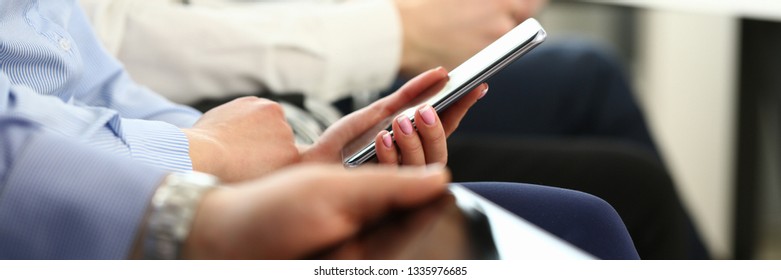 Group millennial business people hold mobile device in hand closeup using wifi background - Shutterstock ID 1335976685