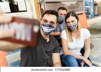 Group Of Millennial People Taking Selfie Outdoor Wearing Protective Mask - Three Friends Man And Woman Sitting Taking Photo With Mobile Phone After Lockdown Reopening - New Normal Concept Stay Safe