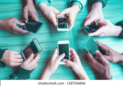 Group of millennials friends using smartphone - People hands view having fun with mobile cell phones - Technology trends and social networks app concept - Main focus on bottom hands cellphones