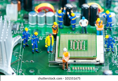 Group Of Miniature Engineers Inspecting Computer Processor