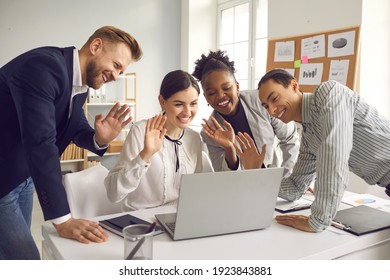 Group Of Mixed Race Office Workers Having Online Video Conference Meeting With International Colleagues. Team Of Happy Diverse Business People Waving Hands At Laptop Computer Saying Hello To Coworkers