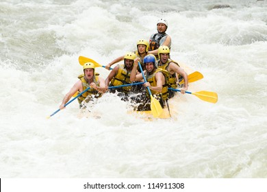 Group Of Mixed Tourist Man And Woman With Guided By Professional Pilot On Whitewater River Rafting In Ecuador