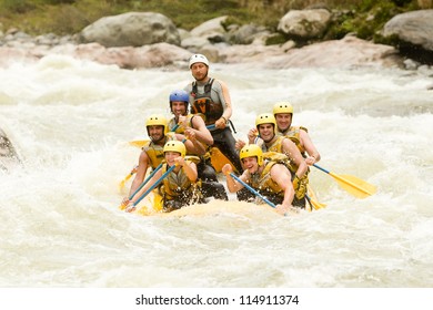 Group Of Mixed Tourist Man And Woman With Guided By Professional Pilot On Whitewater River Rafting In Ecuador