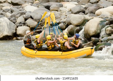 Group Of Mixed Tourist Man And Woman With Guided By Professional Pilot On Whitewater River Rafting In Ecuador