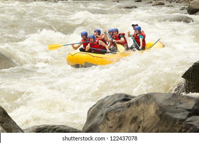 Group Of Mixed Tourist Man And Woman With Guided By Professional Pilot On Whitewater River Rafting In Ecuador