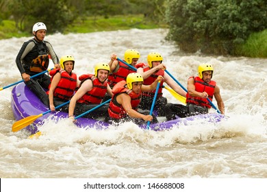 Group Of Mixed Tourist Man And Woman With Guided By Professional Pilot On Whitewater River Rafting In Ecuador