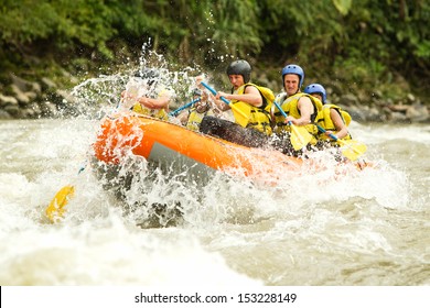 Group Of Mixed Tourist Man And Woman With Guided By Professional Pilot On Whitewater River Rafting In Ecuador