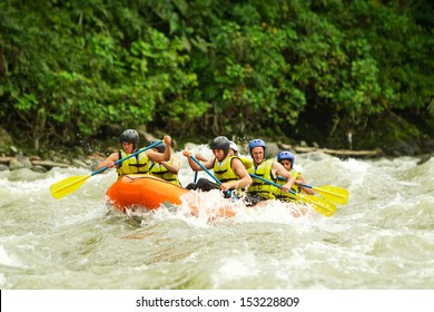 Group Of Mixed Tourist Man And Woman With Guided By Professional Pilot On Whitewater River Rafting In Ecuador