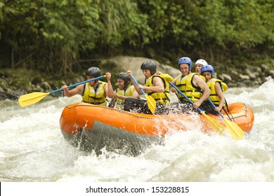 Group Of Mixed Tourist Man And Woman With Guided By Professional Pilot On Whitewater River Rafting In Ecuador
