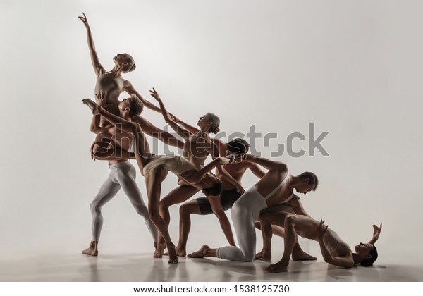 The group\
of modern ballet dancers. Contemporary art ballet. Young flexible\
athletic men and women in ballet tights. Studio shot isolated on\
white background. Negative\
space.