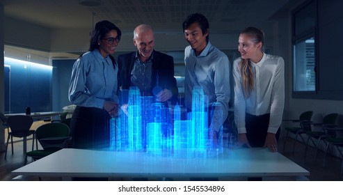 A group of modern designers are using a futuristic sophisticated technology screen with augmented reality holograms for a new project realization in an office. - Powered by Shutterstock